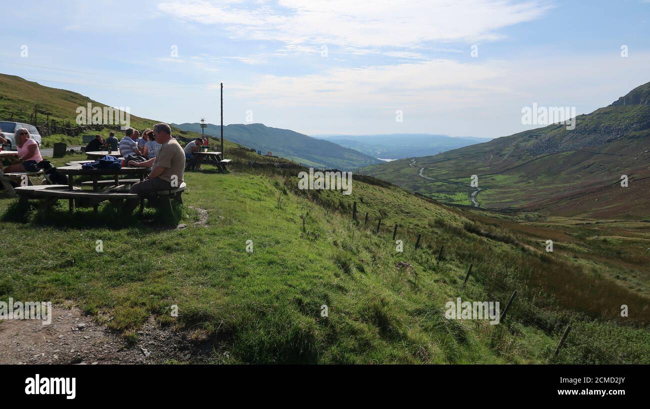 Les gens assis au soleil à Kirkstone Pass Inn Lake District Royaume-Uni Banque D'Images