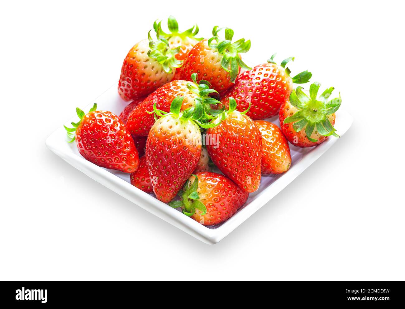 Tas de fraises mûres coréennes bio sur plaque blanche sur fond blanc isolé avec des chemins de coupure. Préparer des fraises fraîches pour la cuisson des salades et Banque D'Images