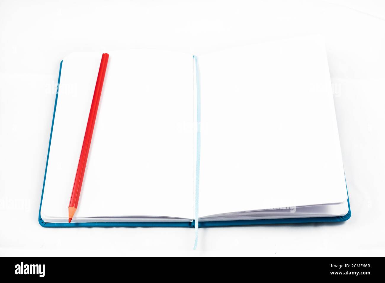 vue de dessus d'un bloc-notes ouvert pour prendre des notes avec un crayon rouge sur fond blanc. concept de conception Banque D'Images