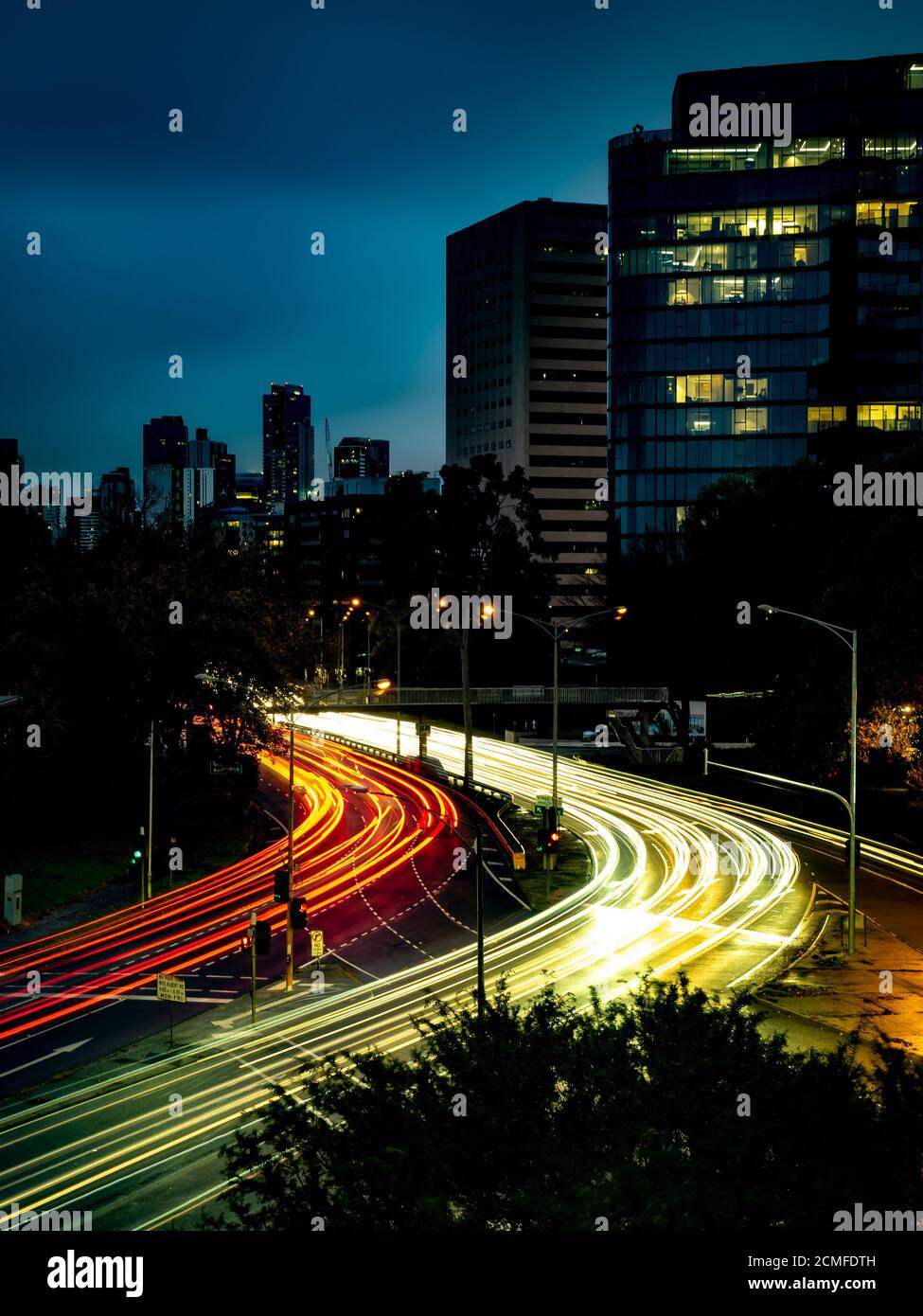 traînées de traînées de lumière sur les voitures qui passent le premier sortie kilda à melbourne pendant les heures de pointe Banque D'Images