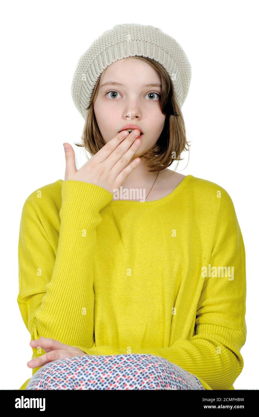 Portrait d'une adolescente qui couvre sa bouche avec sa paume sur un fond blanc. Banque D'Images