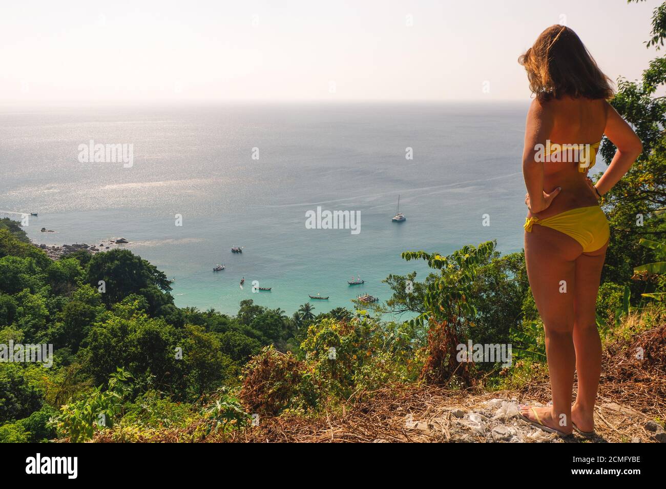 La jeune femme en bikini se tient sur une colline et regarde au-dessus de la plage de Seahaore avec des palmiers. Détendez-vous Banque D'Images