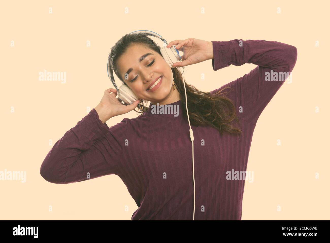 Young happy Indian woman smiling tout en écoutant de la musique avec les yeux fermé Banque D'Images