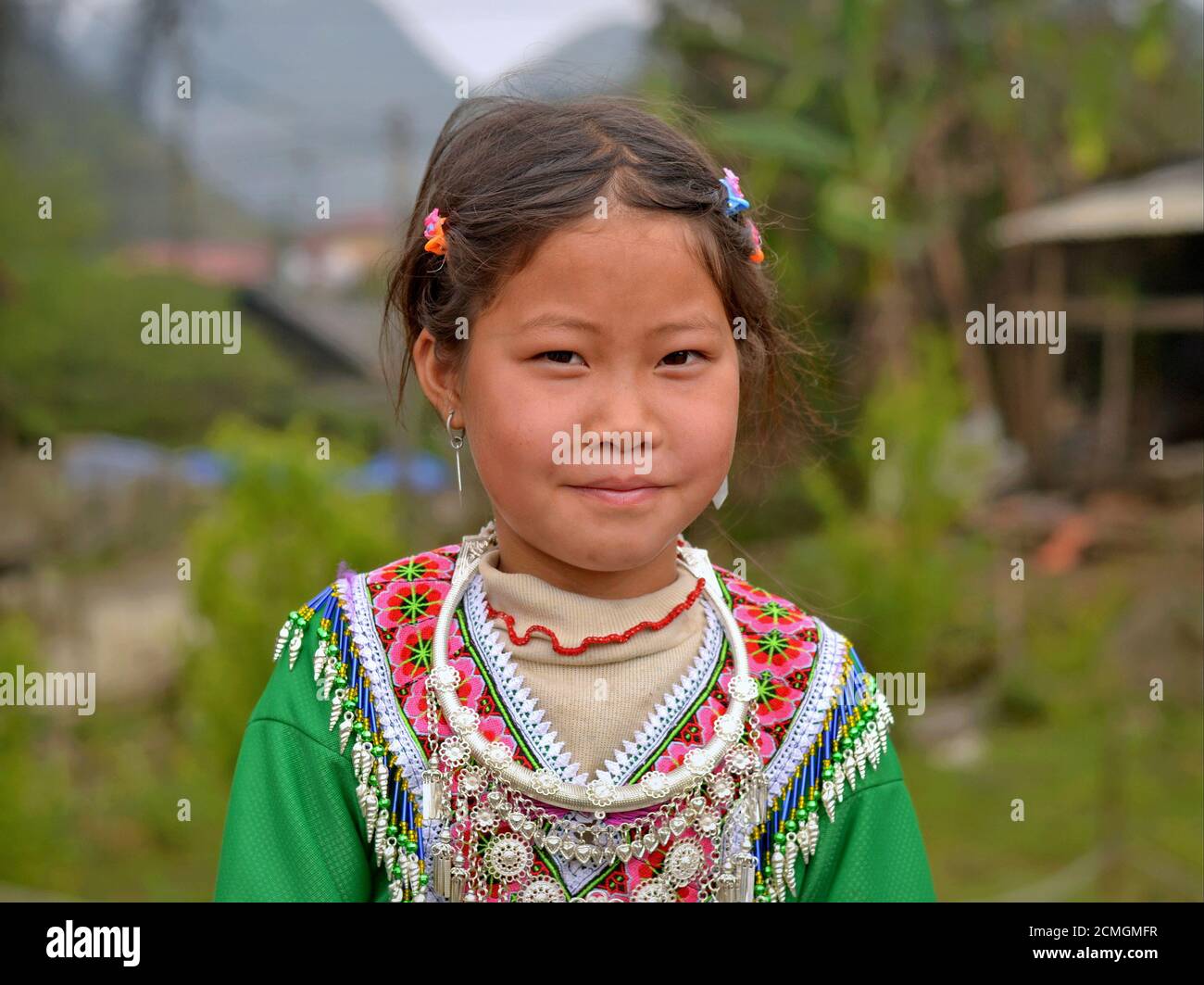 Timide petite fille vietnamienne Hmong en vêtements traditionnels colorés avec  collier d'argent tribal pose pour la caméra Photo Stock - Alamy