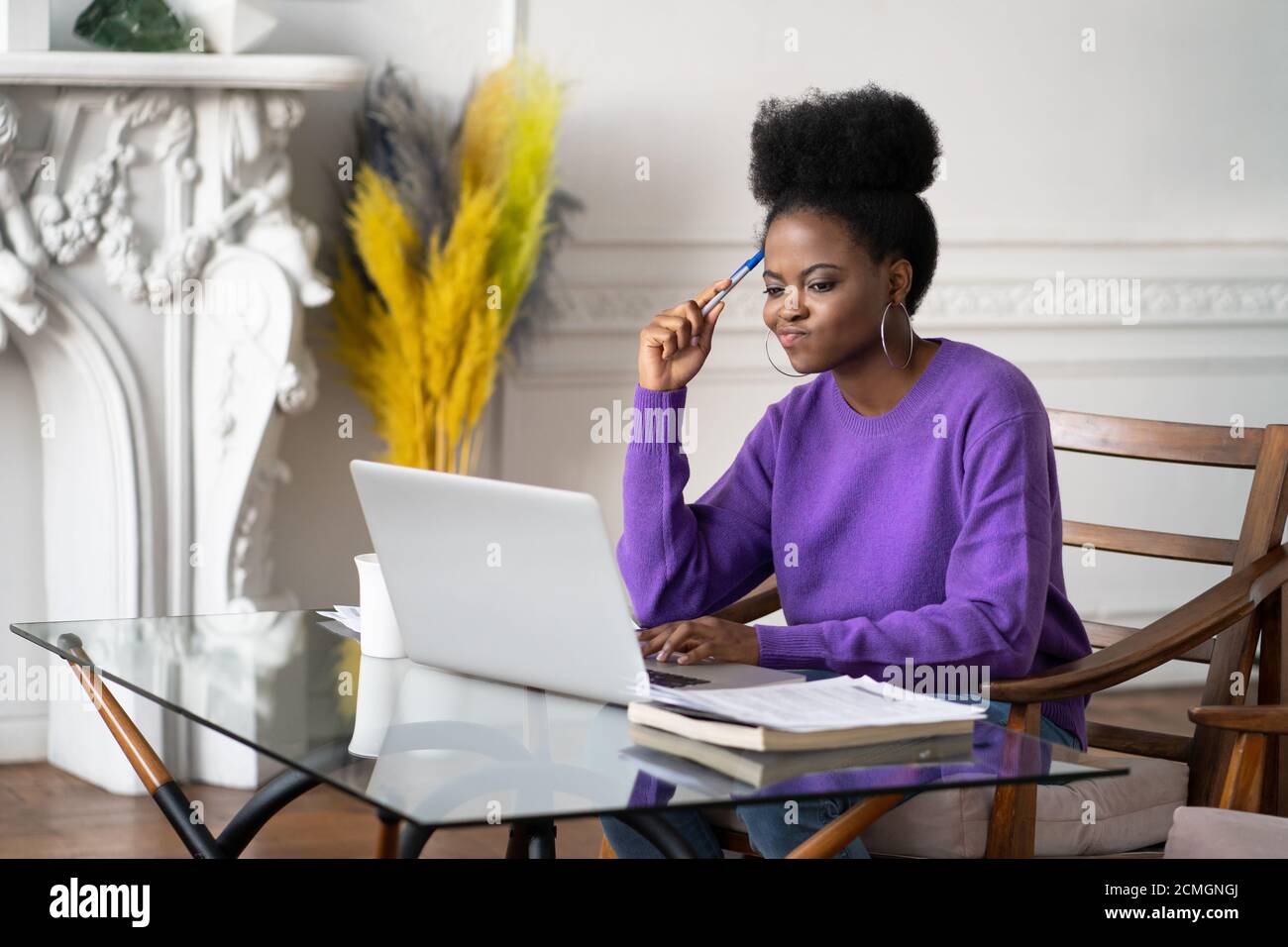 Femme afro-américaine du millénaire avec le visage mécontent de travailler et de regarder l'ordinateur portable, ayant des problèmes de logiciels opérationnels, agacé par la lenteur Banque D'Images