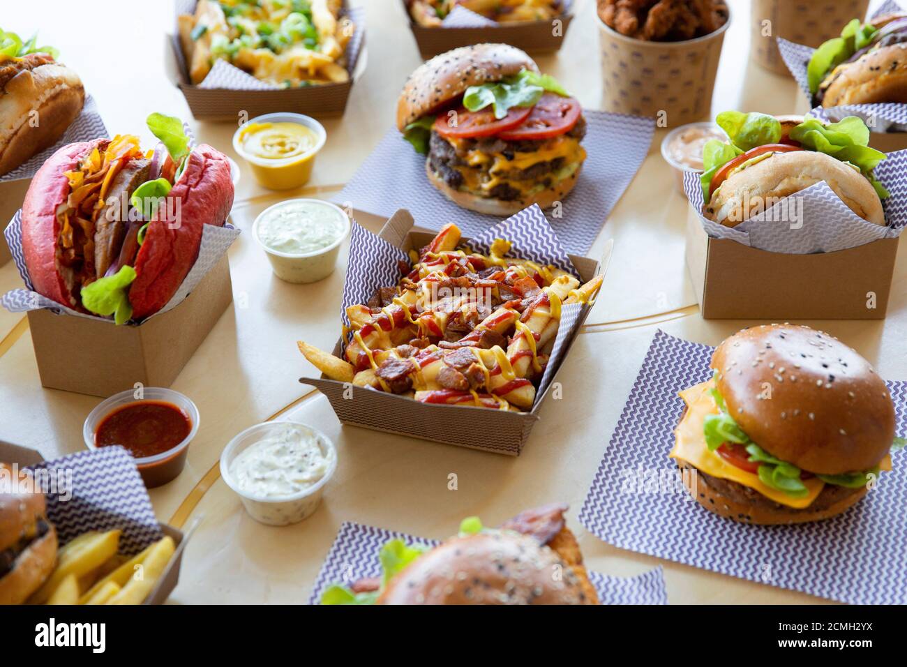 Disposition du restaurant de hamburgers à emporter avec des frites chargées placées avec des sauces et sélection de produits du menu. Banque D'Images