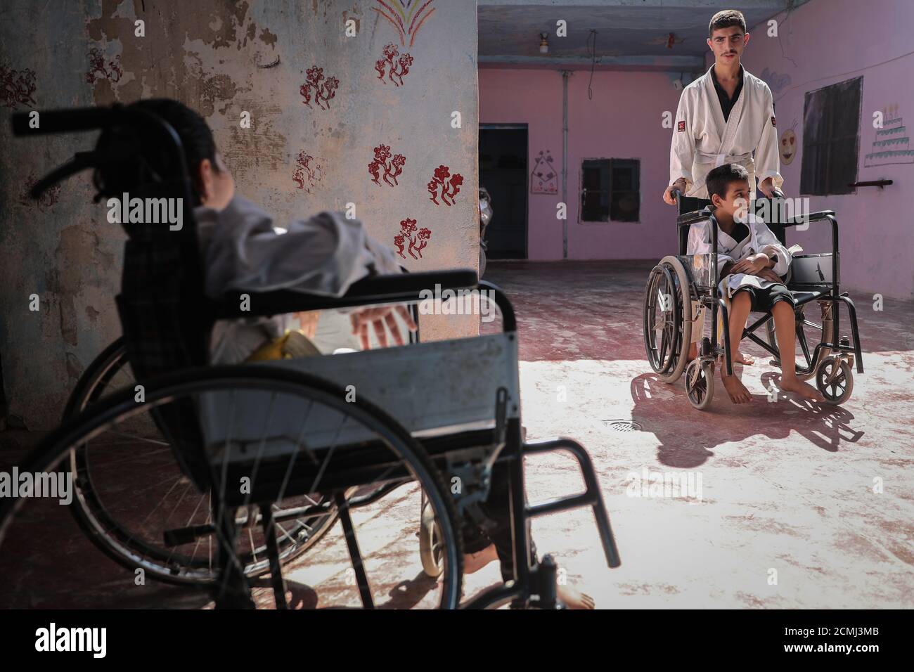 16 septembre 2020, Syrie, Alep : Des enfants en fauteuil roulant arrivent pour assister à un cours de formation de karaté conduit par Wasim Satot, 38 ans, un entraîneur de karaté tenant une ceinture noire, à l'intérieur d'une école appartenant à sa mère pour des enfants à besoins spéciaux tels que le syndrome de Down·s, l'autisme et d'autres handicaps, dans le village d'Aljiina dans la campagne d'Alep. Wasim est un professeur d'éducation physique a commencé son propre projet de karaté il y a un an, dans lequel il était désireux de fusionner entre 10 enfants à besoins spéciaux et d'autres 10 enfants en bonne santé de 6 à 15 ans dans une classe de formation de karaté pour les intégrer ensemble dans la société thr Banque D'Images