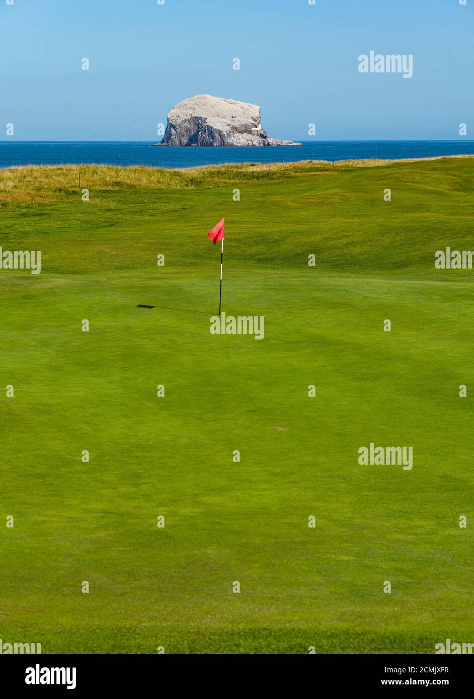 East Lothian, Écosse, Royaume-Uni, 17 septembre 2020. Météo au Royaume-Uni : la vague de chaleur la rend sur la côte est de l'Écosse. Une broche de golf dans un trou sur le terrain de golf Glen à North Berwick sur le sommet de la falaise avec une vue sur la colonie de gannet de Bass Rock. Banque D'Images