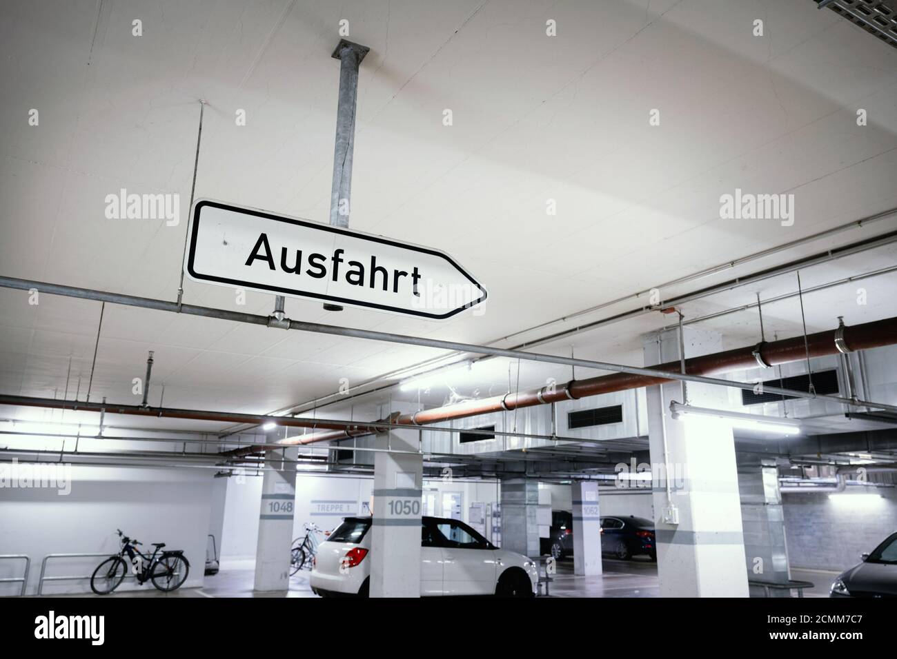 Depuis le plafond d'un parking souterrain, un panneau indiquant « Ausfahrt » - sortie est suspendu. Banque D'Images
