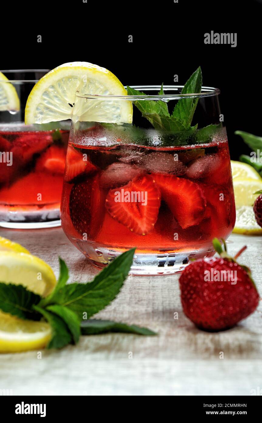 Un verre de limonade aux fraises réfrigérés, les feuilles de menthe, une rondelle de citron avec de la glace Banque D'Images
