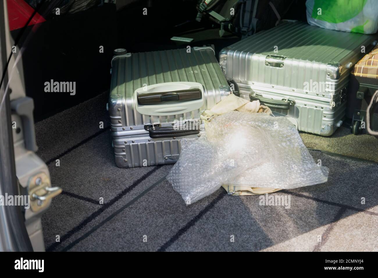 Un bagage est déposé sur le plancher du coffre d'une voiture Banque D'Images