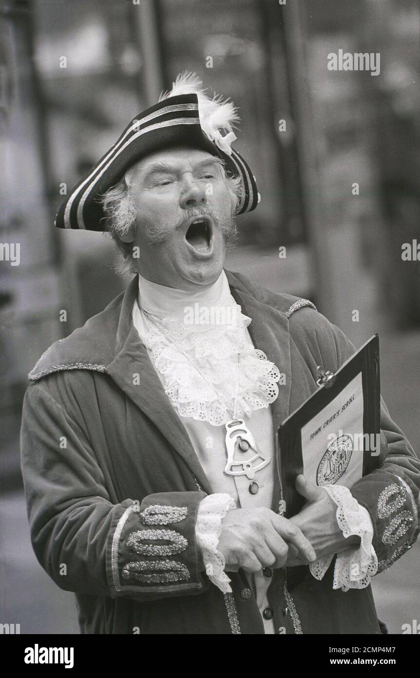 1987, une ville criant dans son costume et tenant un rouleau, faisant une annonce publique, York, Angleterre, Royaume-Uni. La tradition remonte à l'époque médiévale où les informations de la ville crier sur les nouvelles lois, les décrets royaux, les naissances, les pièces de théâtre, les magasins etc. Ont été appelés dans le centre des villes anglaises pour que beaucoup de gens puissent l'entendre et le comprendre. Un crieur de ville est tout au sujet du message, donnant un avis public par proclamation forte et ils existent toujours dans beaucoup de villes anglaises aujourd'hui. Banque D'Images
