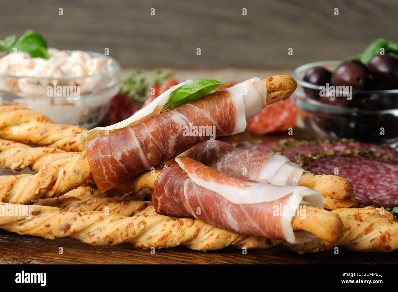 Plat pour encas Antipasto avec salami, bâtonnets de pain (Grissini) enveloppés d'olives prosciutto et de chis Banque D'Images