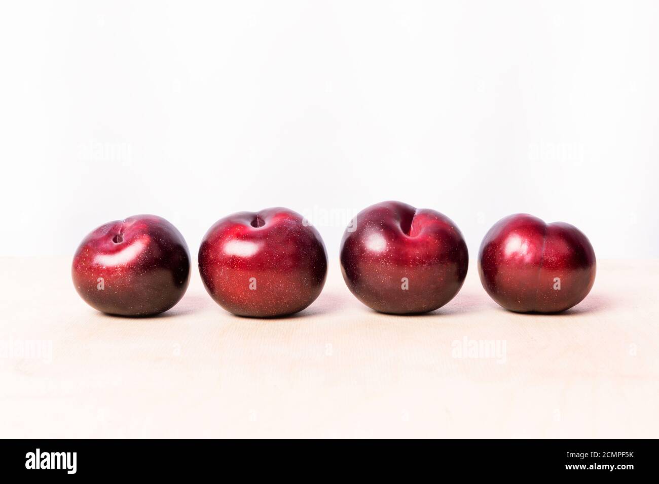 Prune rouge sur fond blanc isolé Banque D'Images