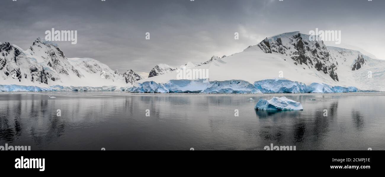 Tôt le matin à l'île Danco sur la péninsule antarctique. Les montagnes majestueuses mènent un glacier vers une mer calme. Banque D'Images