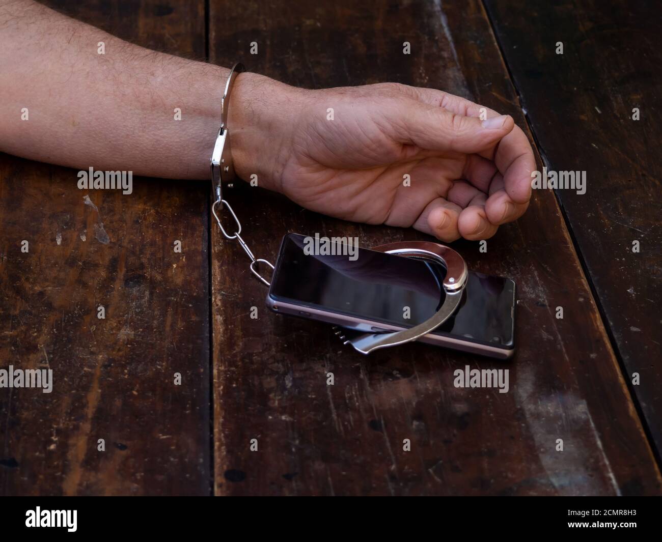 Un homme menotté à un smartphone. Concept de dépendance à Internet ou Smartphone Banque D'Images