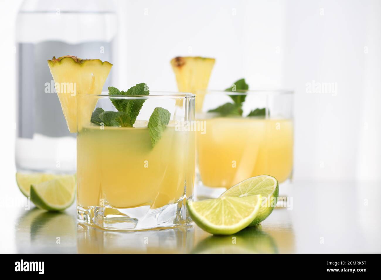 Cocktail Gin avec du jus d'ananas, une tranche de lime, refroidi avec de la glace et la menthe Banque D'Images