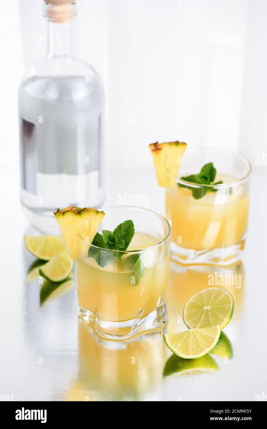 Cocktail Gin avec du jus d'ananas, une tranche de lime, refroidi avec de la glace et la menthe Banque D'Images