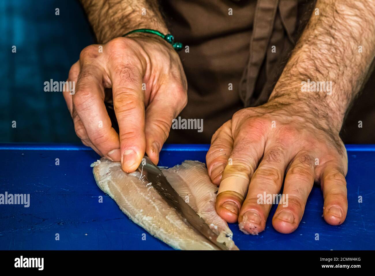 Comment arrondir une truite ? Laszlo Papdi explique la technique de coupe dans la cuisine lors d'un cours à l'Institut culinaire de Budapest, Hongrie Banque D'Images