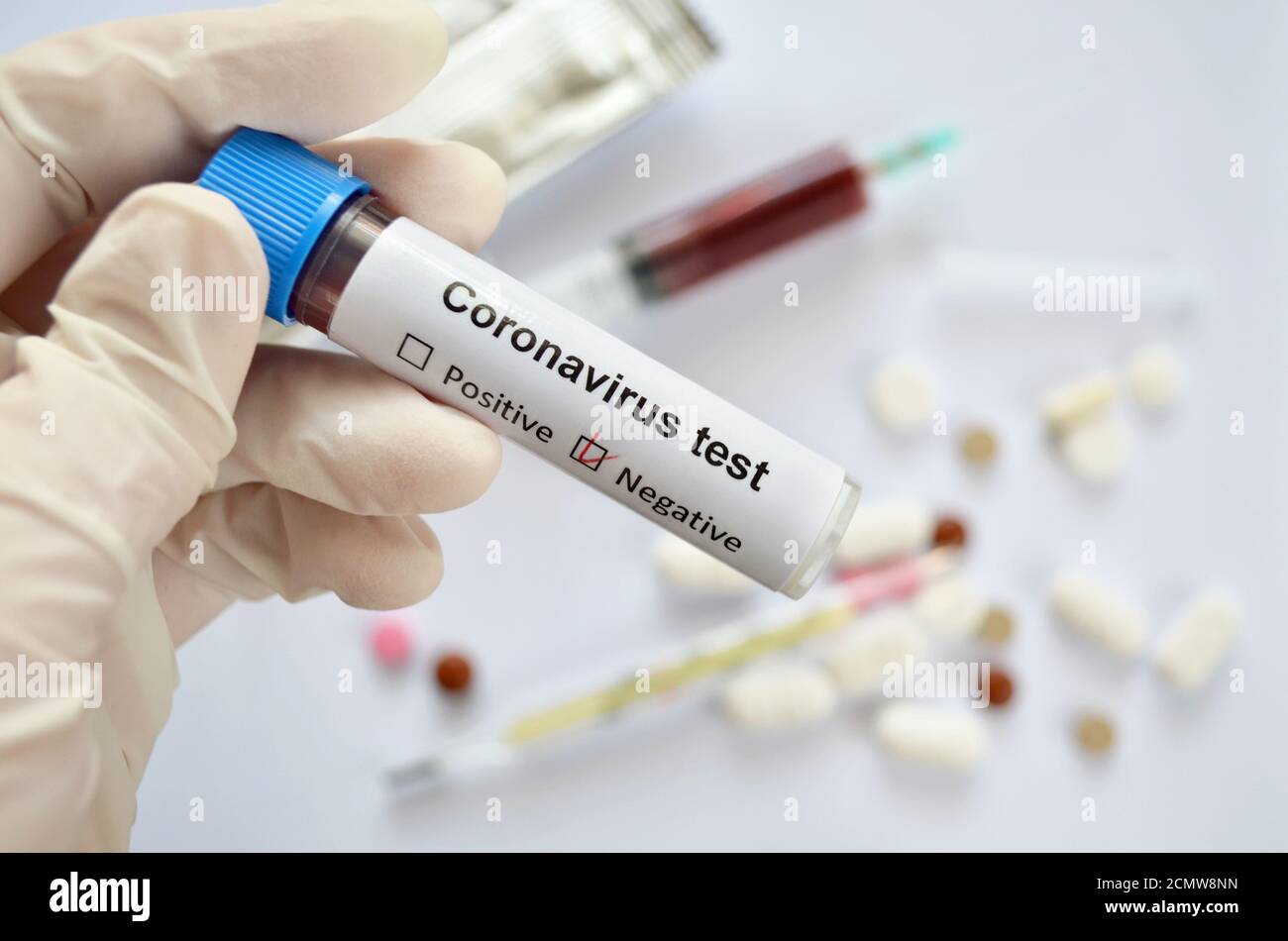 Tube à essai avec un échantillon de sang et un test négatif résultat pour une infection à coronavirus dans la main d'un travailleur médical Banque D'Images