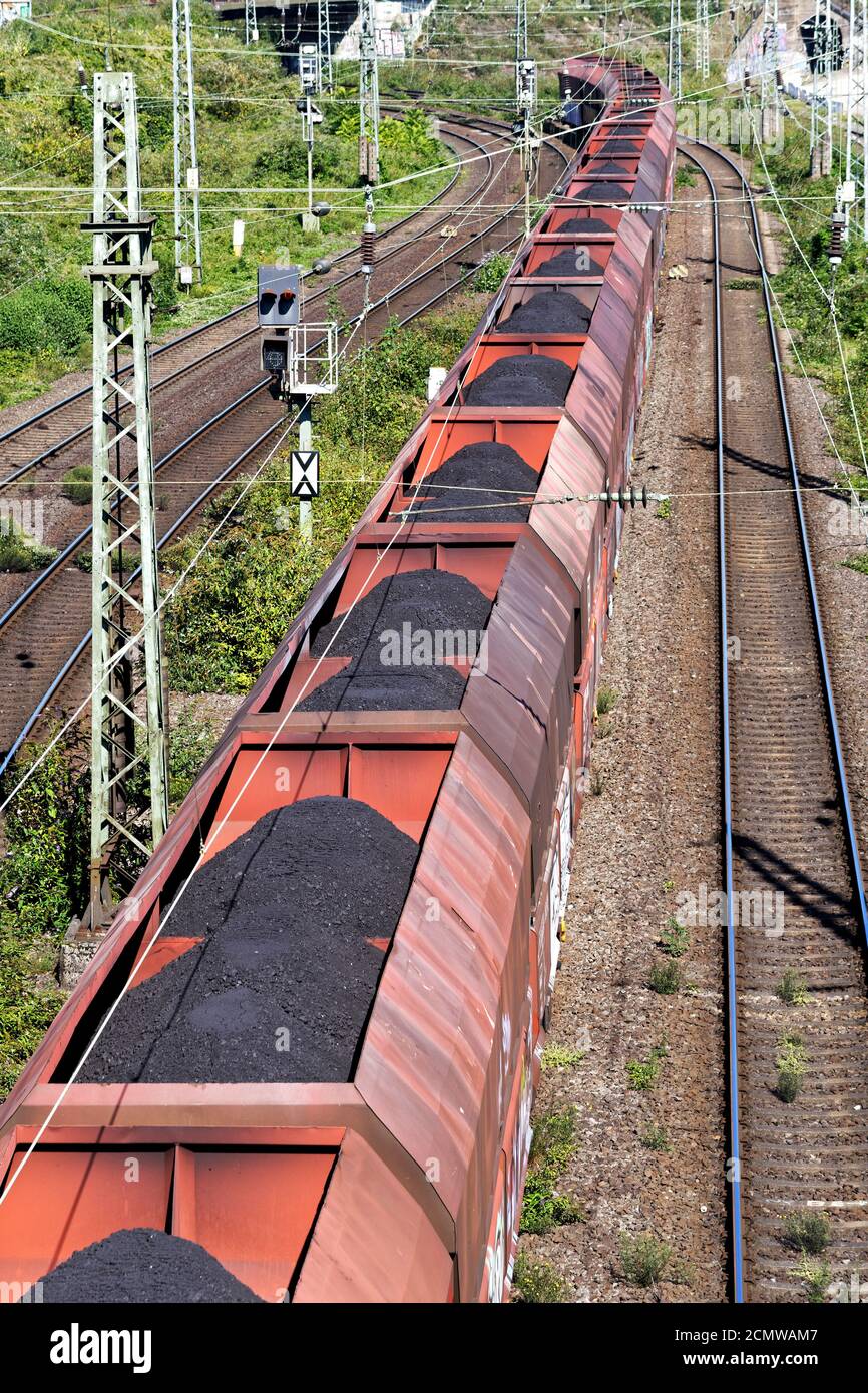 un long train à charbon passe sous un pont à cologne Banque D'Images