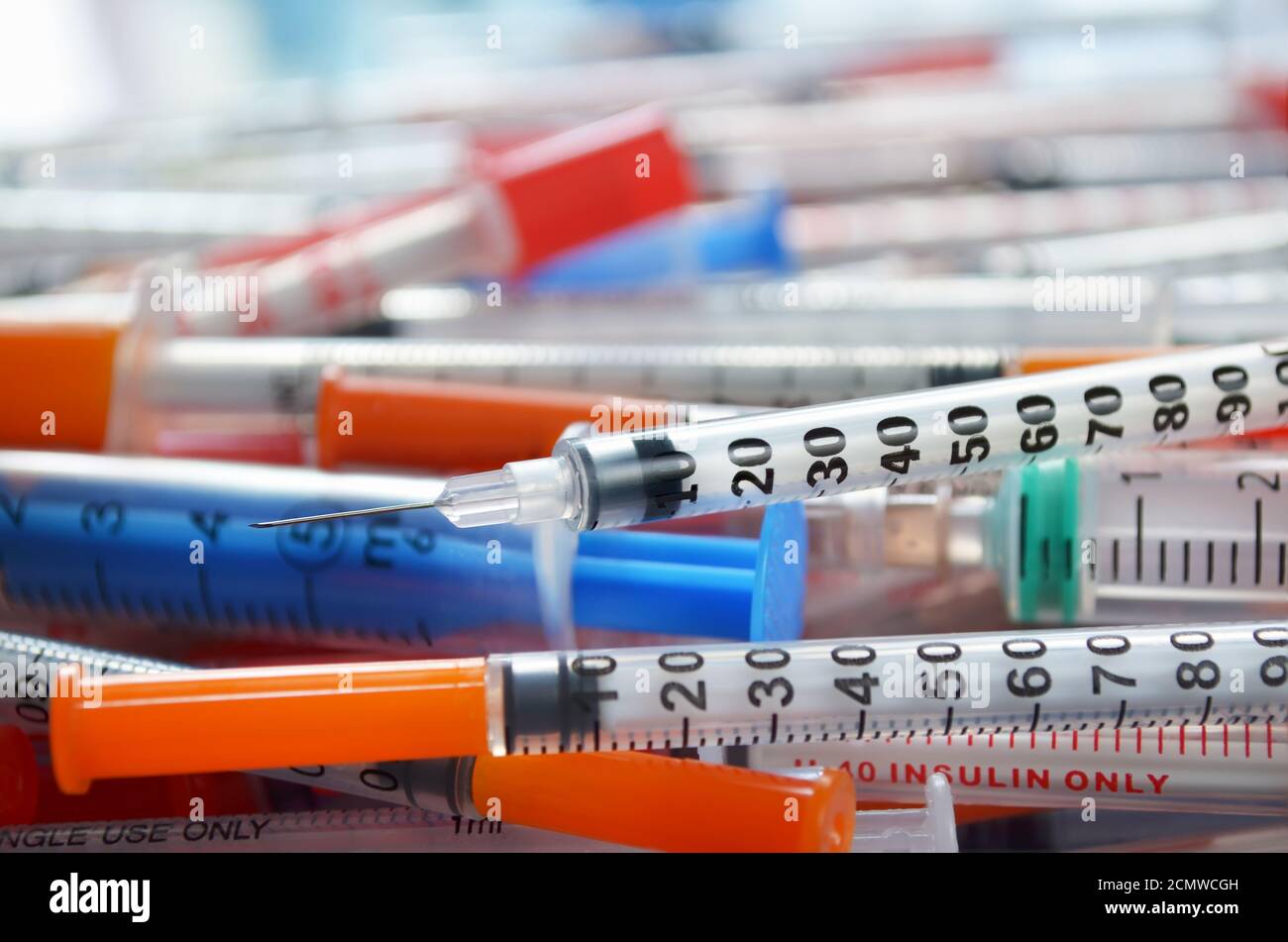 Seringue d'insuline avec aiguille ouverte en gros plan sur le fond d'autres seringues jetables. Faible profondeur de champ. Concept de soins de santé Banque D'Images