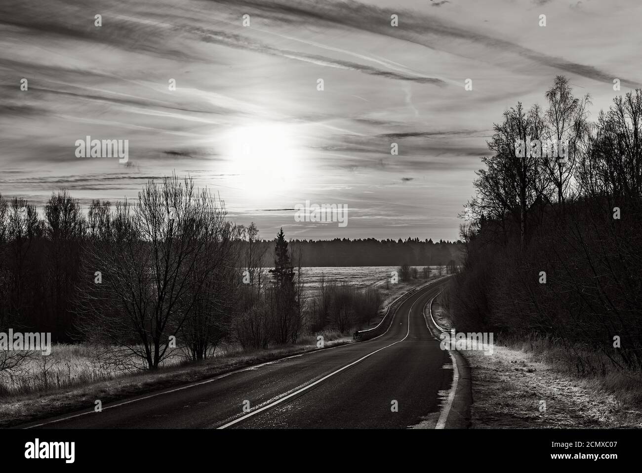 route de paysage en noir et blanc au coucher du soleil Banque D'Images