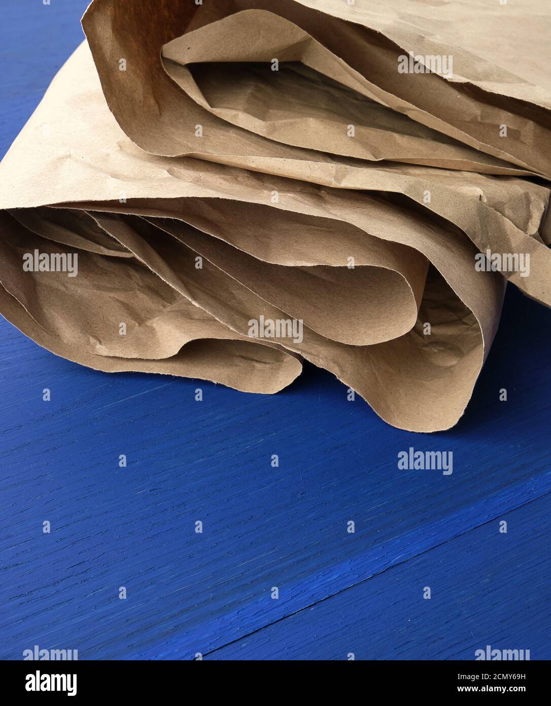 feuille de papier kraft froissés brun sur fond de bois bleu Banque D'Images