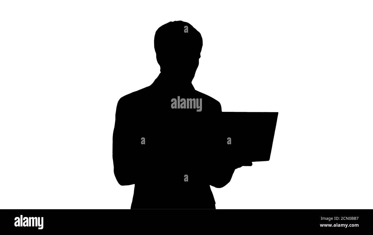 Silhouette a concentré les jeunes hommes d'affaires travaillant sur le whil d'ordinateur portable Banque D'Images