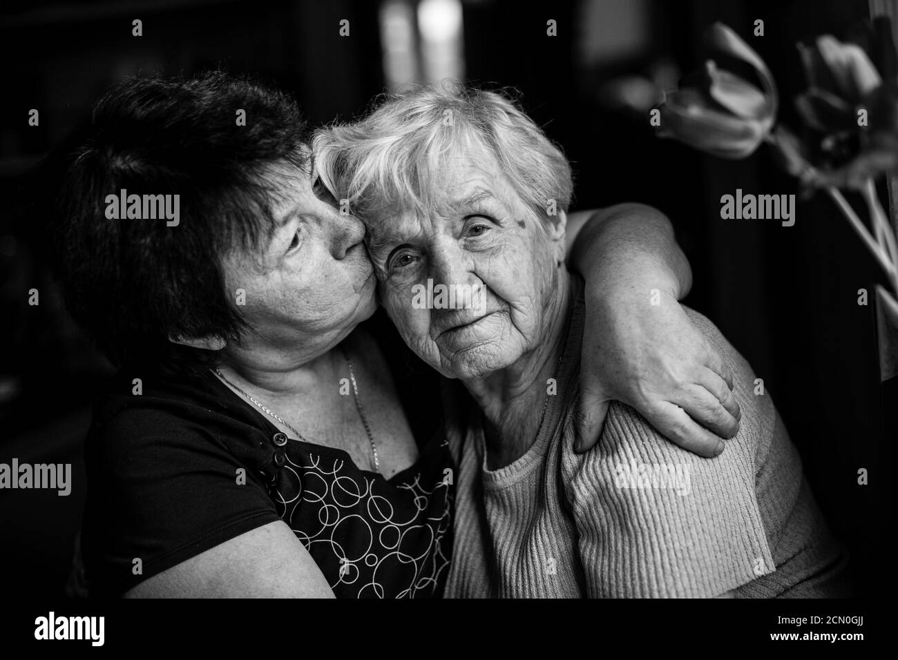 Une vieille femme embrasse avec sa fille adulte. Photographie en noir et blanc. Banque D'Images