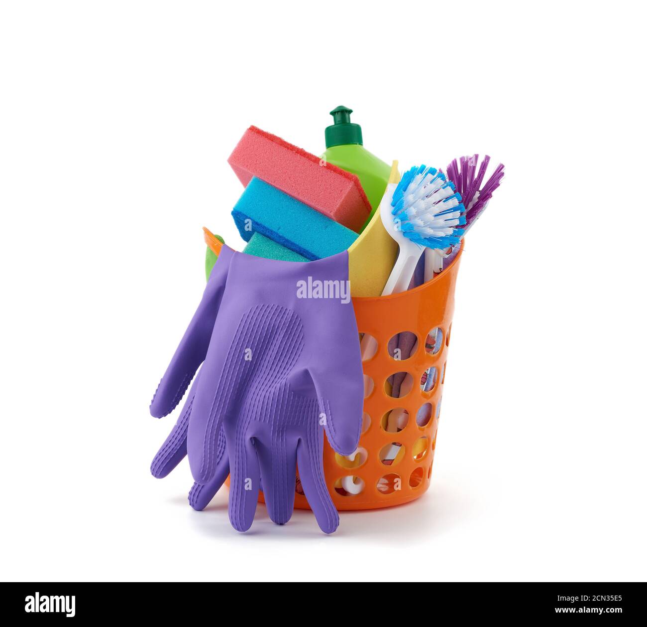 panier orange avec éponges de lavage, gants de protection en caoutchouc, brosses et agent de nettoyage dans un vert Banque D'Images