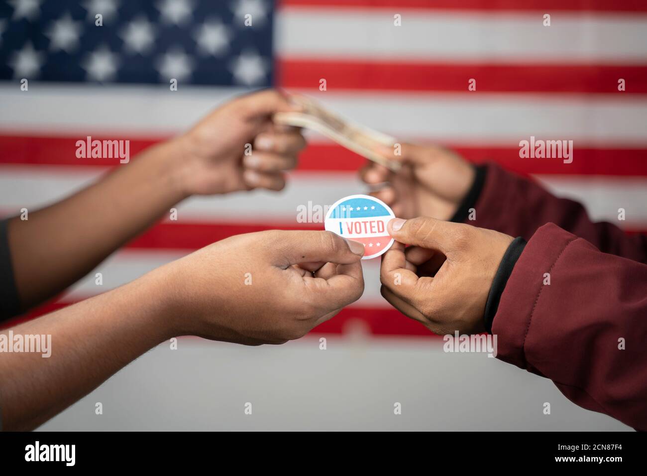 Concept d'achat de votes lors des élections américaines en échangeant j'ai voté autocollant avec de l'argent sur le drapeau américain comme fond. Banque D'Images