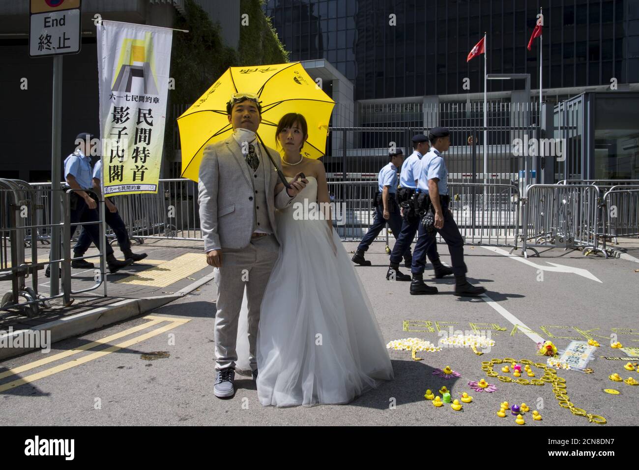 Un couple de Hong Kong tenant un parapluie jaune, le symbole du mouvement  Occupy Central, pose lors d'une séance photo avant le mariage devant le  quartier général du gouvernement, alors que des