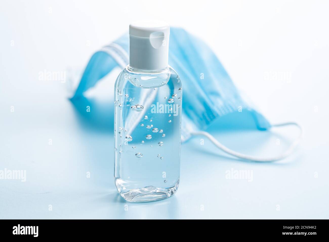 Gel antibactérien pour les mains et masques sur fond bleu. Protection contre les coronavirus. Banque D'Images