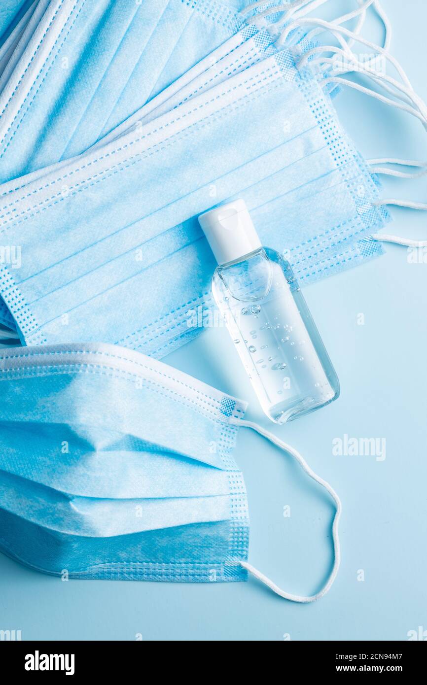 Gel antibactérien pour les mains et masques sur fond bleu. Protection contre les coronavirus. Banque D'Images
