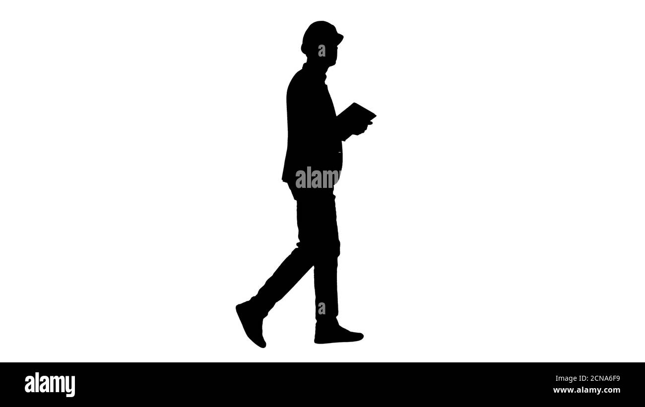Silhouette Architect se promenant avec une tablette et vérifiant ce qui est construit. Banque D'Images