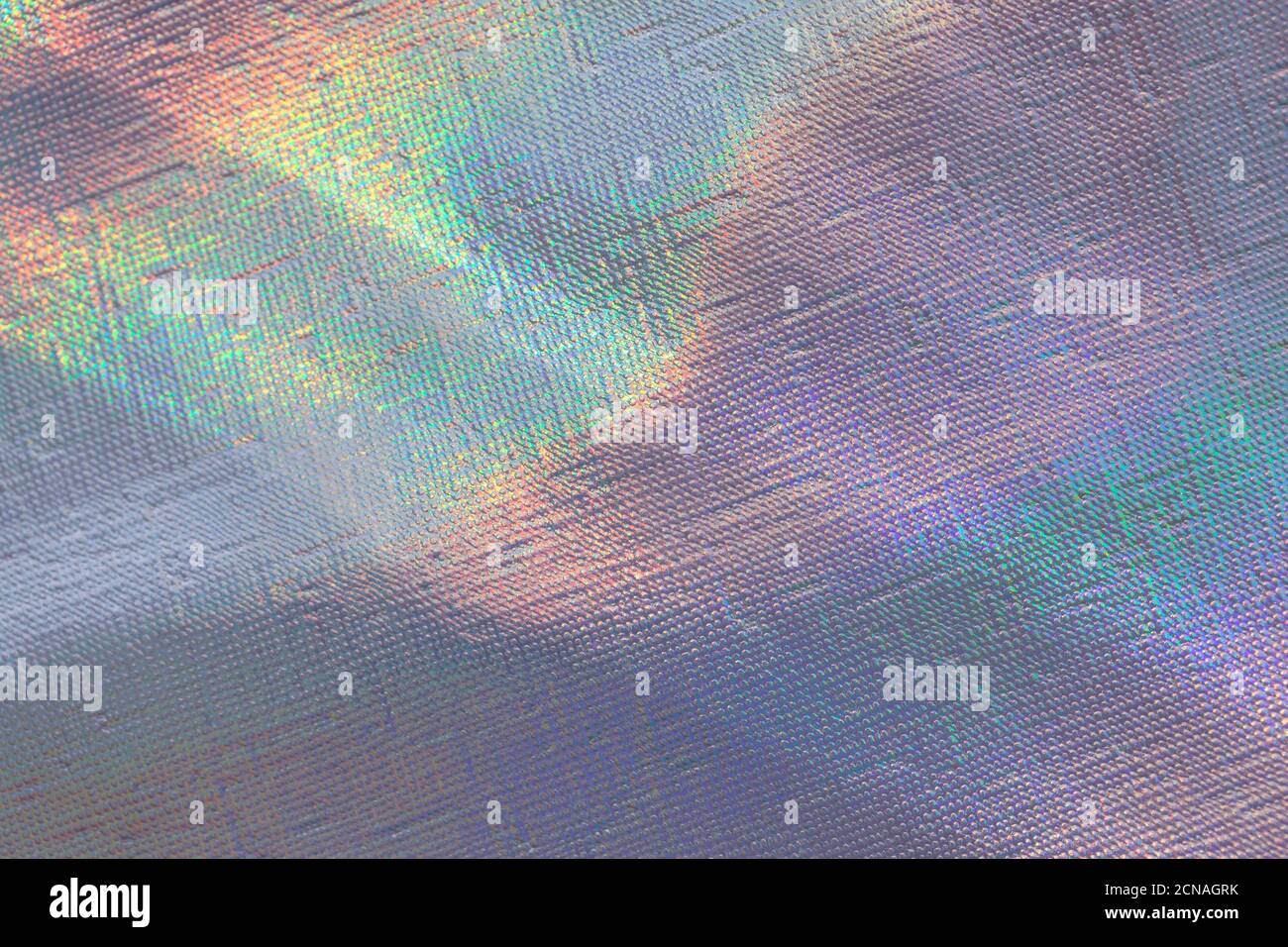 Photo d'un véritable arc-en-ciel de lumière froissés fond holographique avec une texture de peau avec des rayons de lumière du jour. Banque D'Images