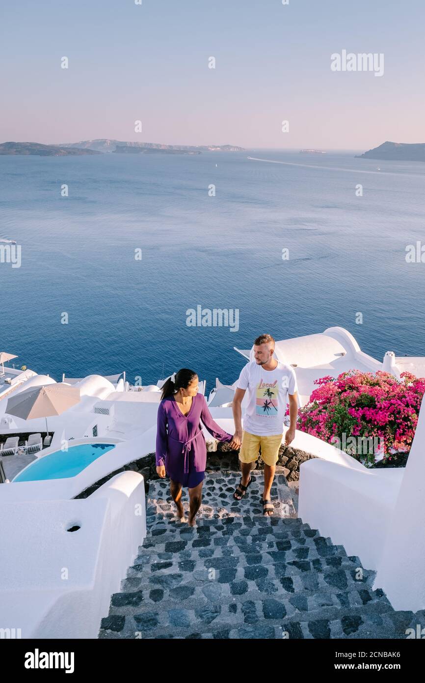 Santorini Grèce, jeune couple en vacances de luxe à l'île de Santorini regardant le lever du soleil à côté de l'église du dôme bleu et blanchir Banque D'Images