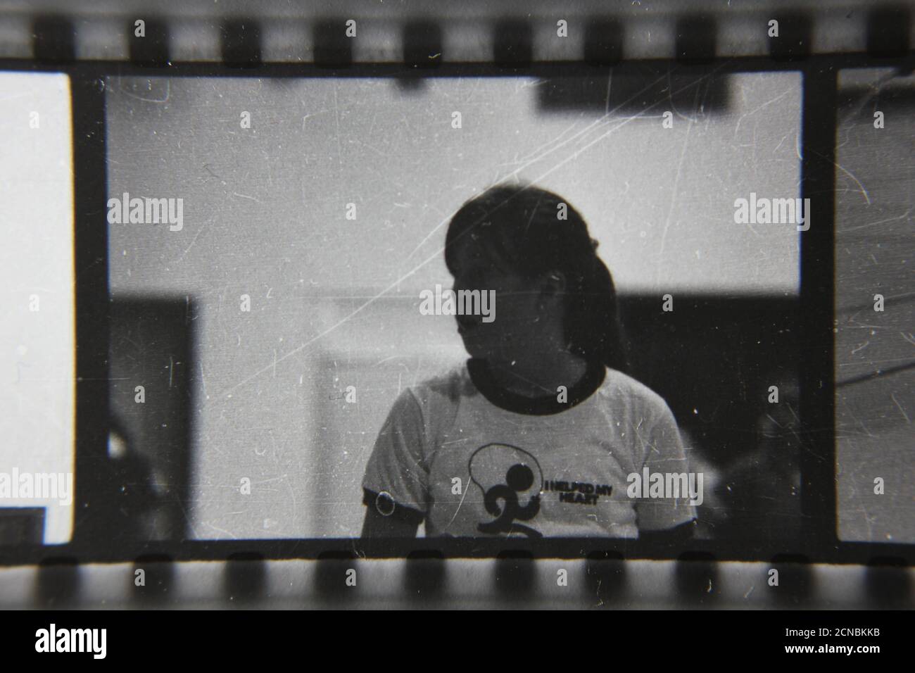 Belle photographie en noir et blanc vintage des années 1970 d'une jeune femme regardant à côté dans le gymnase de l'école. Banque D'Images