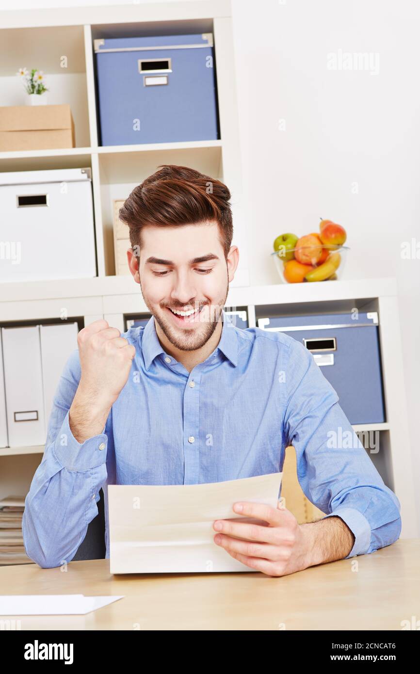 Un jeune homme qui applaudit lit une lettre avec un poing fermé Banque D'Images