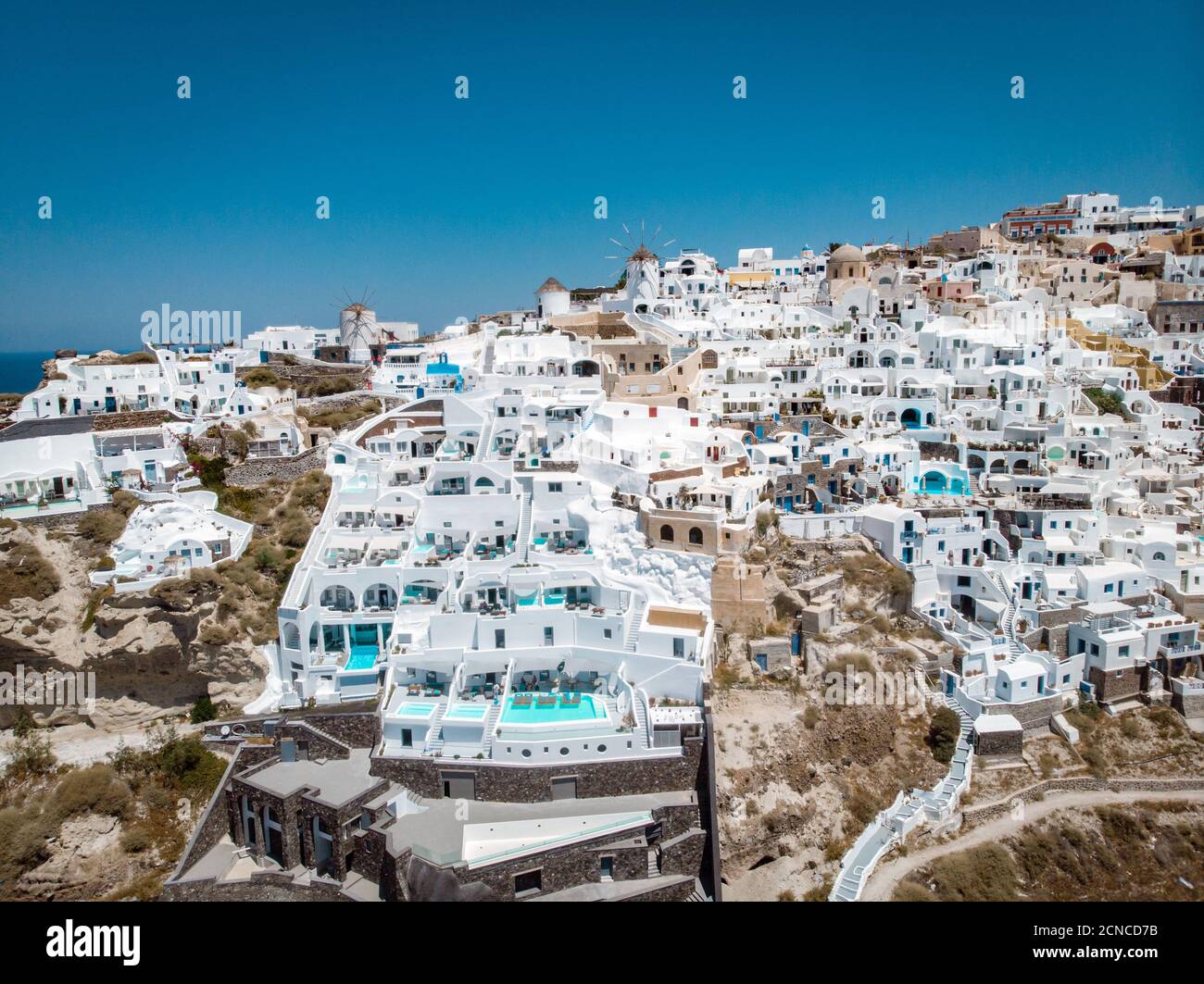 Vue sur Santorin, vue aérienne sur le village blanchi à la chaux d'Oia avec station de vacances de luxe avec piscines à débordement à sa Banque D'Images
