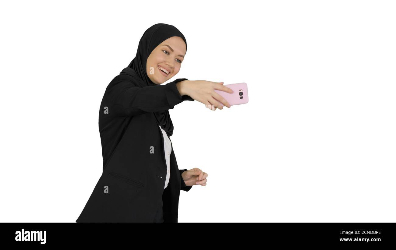 Femme arabe souriante dans le hijab prenant des selfies sur son mobile téléphone a Banque D'Images