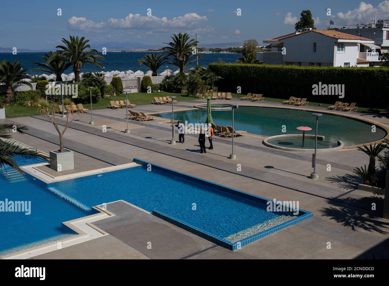 Les employés discutent à côté des piscines de l'hôtel Divani Apollon Palace, le premier jour de l'ouverture des hôtels en Grèce, après un verrouillage national contre la propagation de la maladie du coronavirus (COVID-19), à Athènes, Grèce, le 1er juin 2020. REUTERS/Almais Konstantinidis Banque D'Images