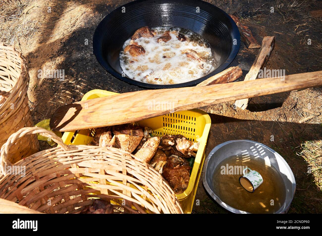 Gros plan de la viande de porc friture à l'huile chaude dans une poêle à wok sur un foyer traditionnel dans une maison philippine, appelée cuisine sale Banque D'Images