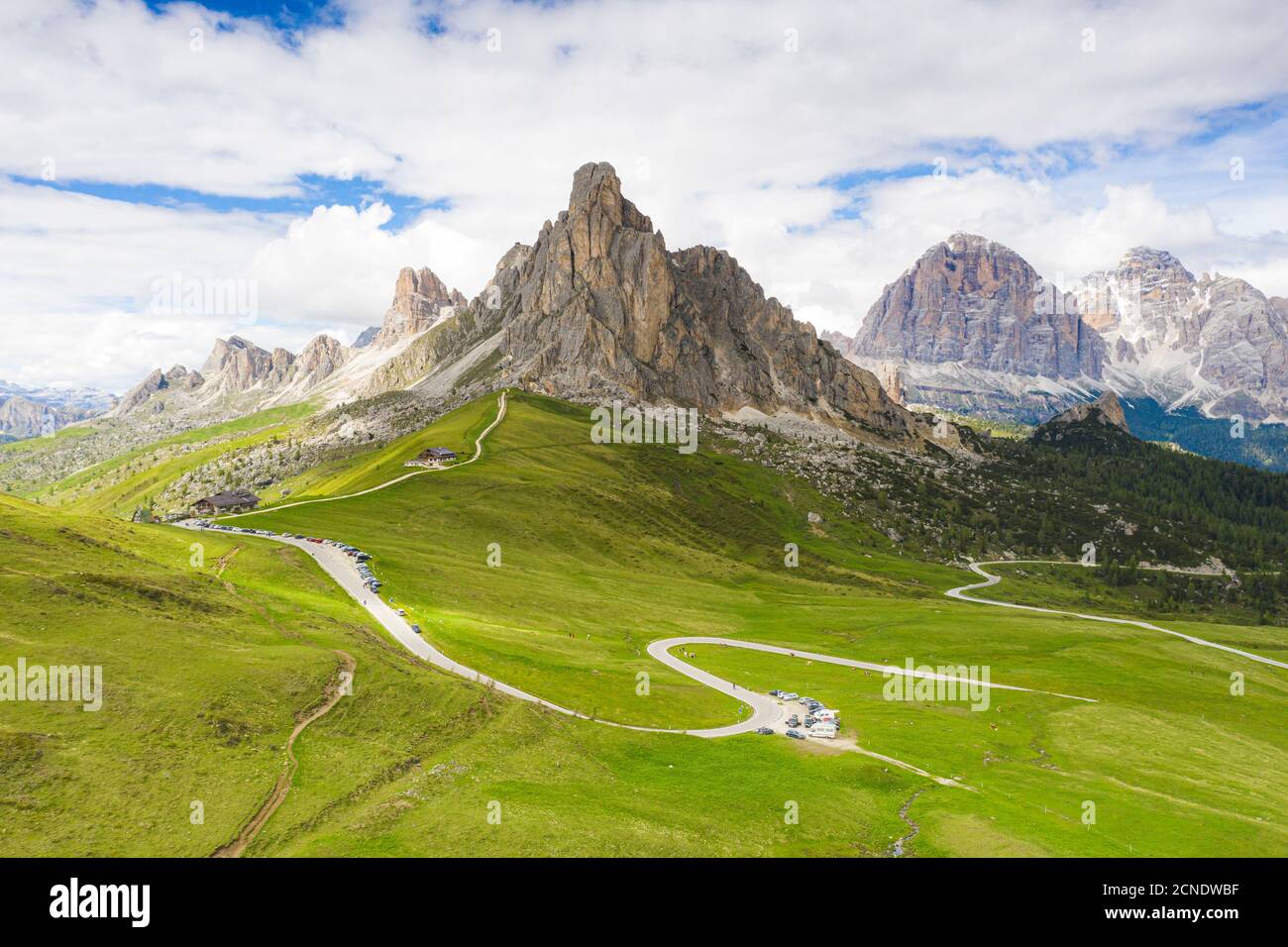 Route sinueuse du col de Giau dans le paysage vert avec les montagnes de Ra Gusela et Tofane en arrière-plan, Dolomites, Vénétie, Italie, Europe Banque D'Images