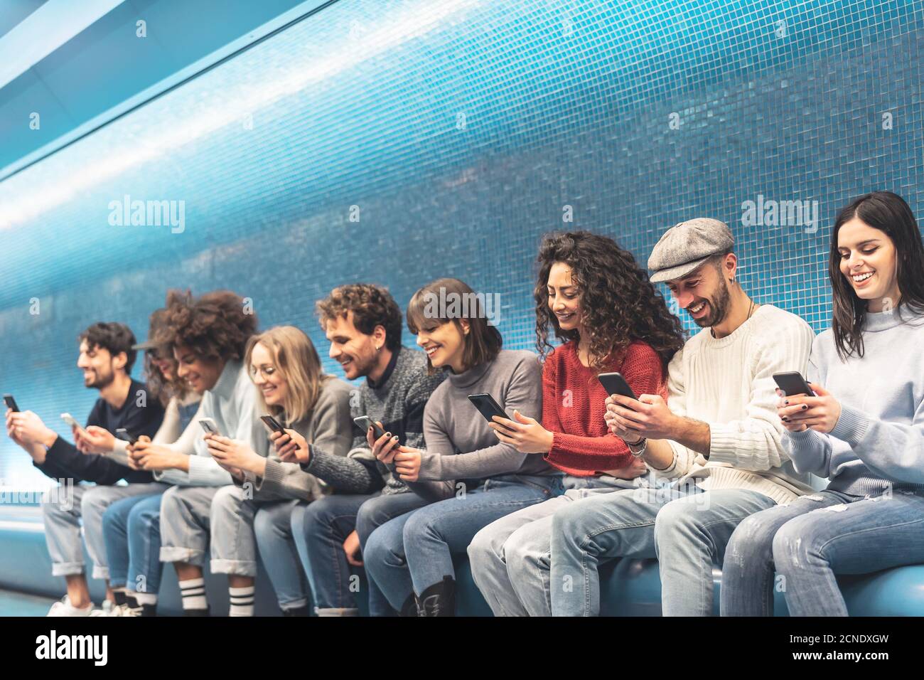 Des amis heureux utilisant un smartphone mobile à la station de métro - Young les gens s'amusent avec les nouvelles tendances des applications de médias sociaux Banque D'Images