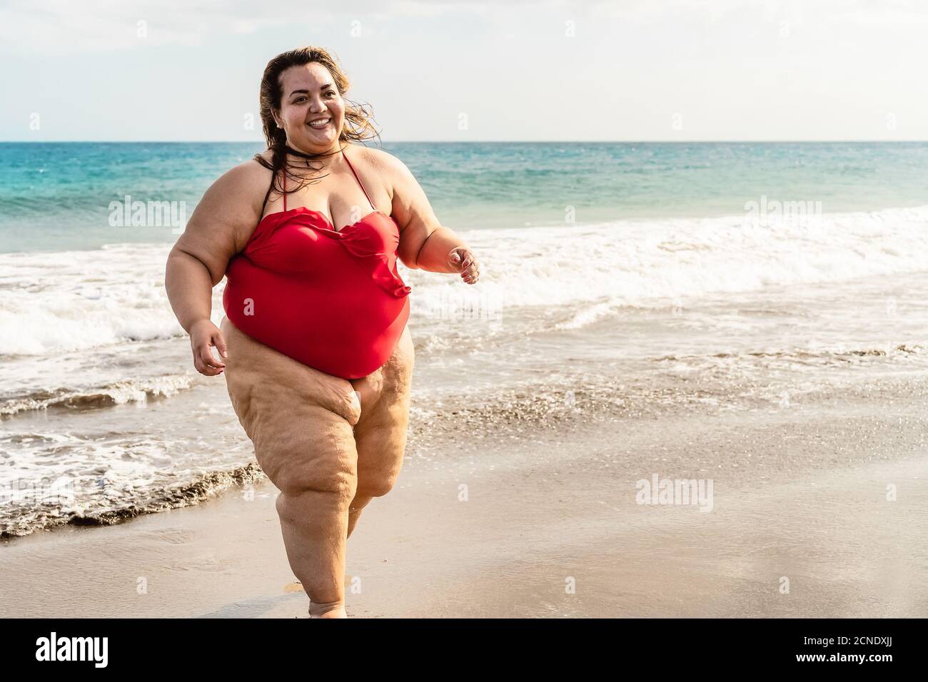 Bonne femme de taille plus courant sur la plage - Curvy modèle en surpoids  s'amusant pendant les vacances dans une destination tropicale Photo Stock -  Alamy