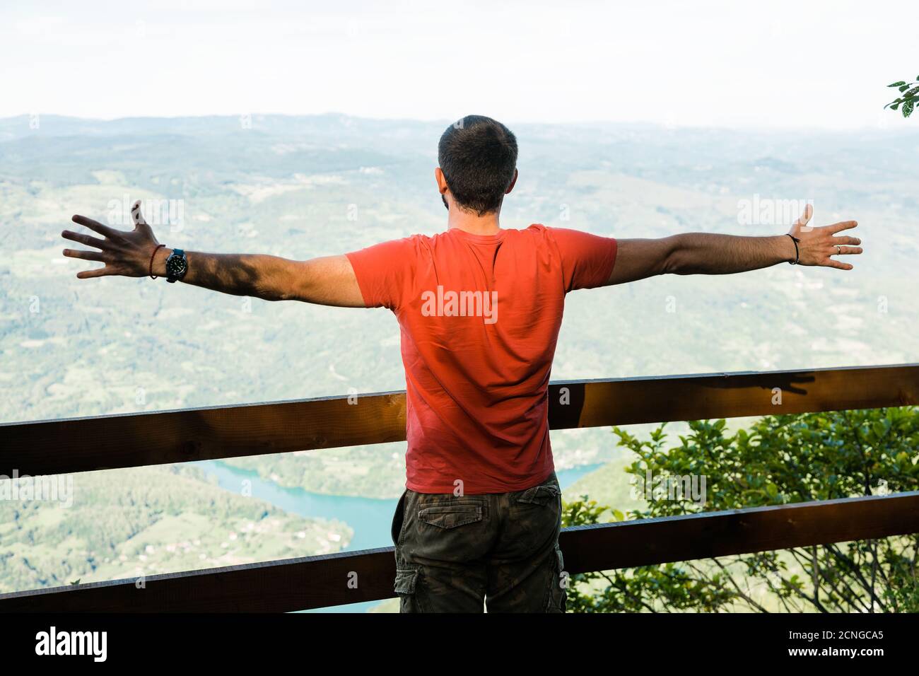 Jeune homme dans la montagne appréciant la vue de la lac Banque D'Images