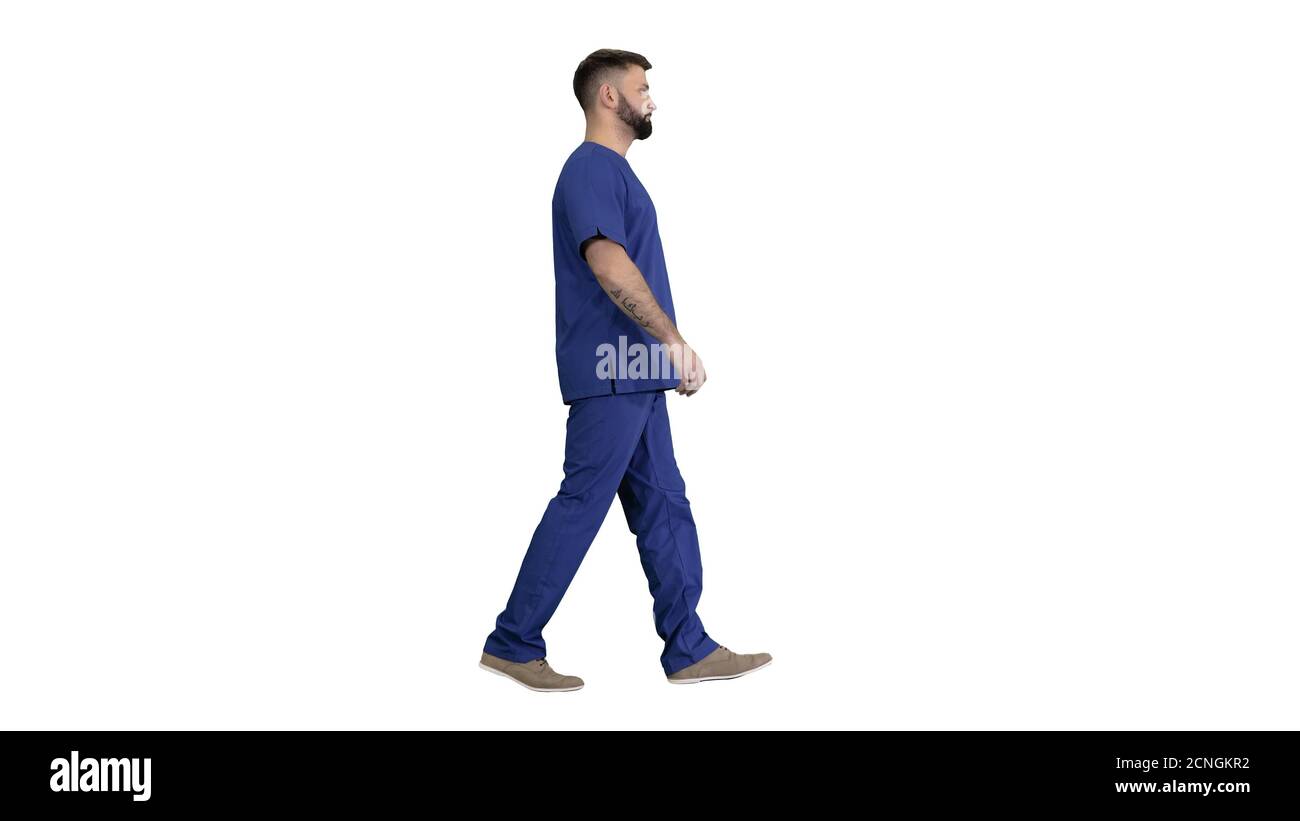 Chirurgien masculin sérieux avec une barbe marchant sur fond blanc. Banque D'Images