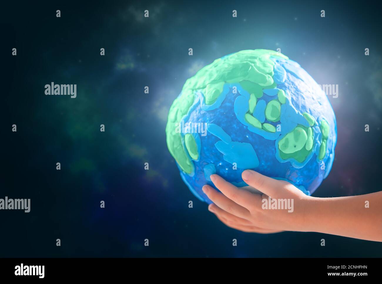 Enfant tenant la planète entre les mains contre l'arrière-plan de l'espace. Concept de vacances jour de la terre. Banque D'Images